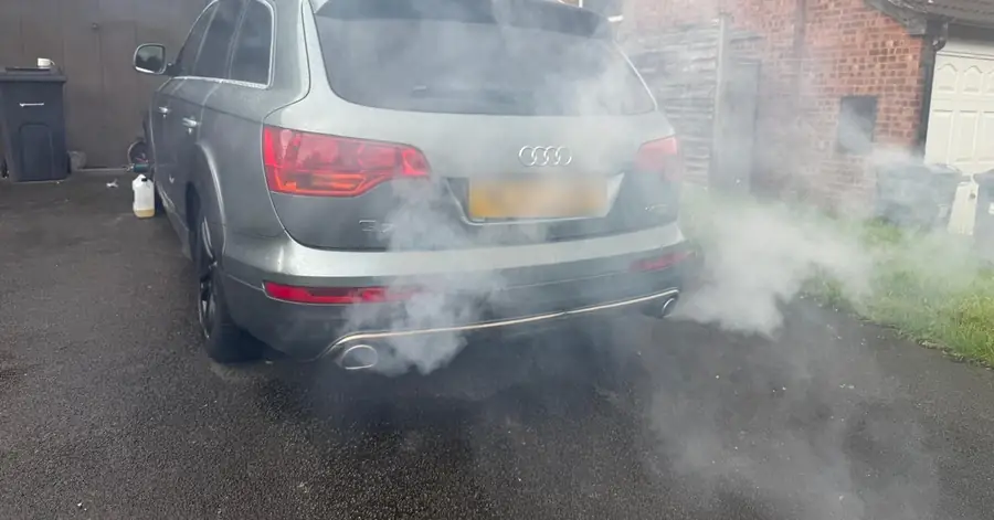 Grey Audi Q7 on a driveway with smoke from both exhaust pipes during a DPF clean